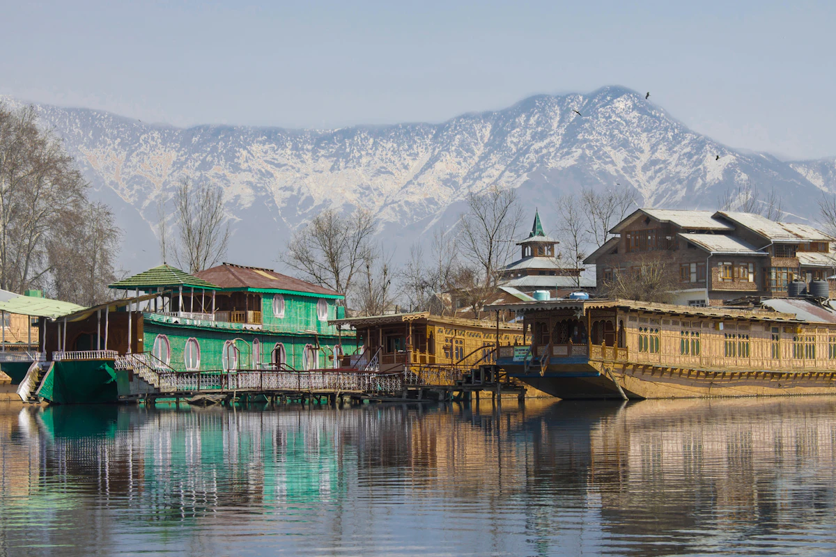 Houseboats on a lake below snowy peaks in Kashmir